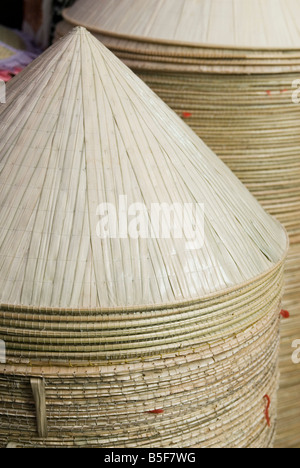 Chapeaux de paddy ou de chapeaux de paille coniques pour la vente à un décrochage du marché de Cholon, le marché Binh Tay, Ho Chi Minh City, Vietnam Banque D'Images