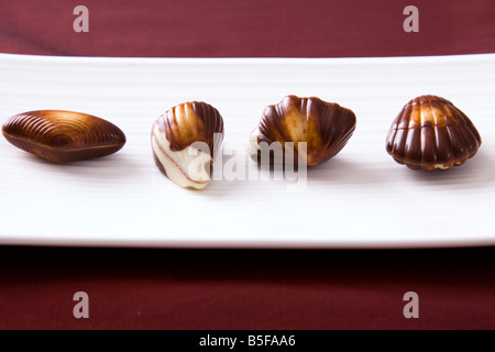 Quatre chocolats assortis disposés sur une plaque Banque D'Images