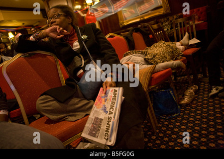 Dame afro-américain fatigué dormir avec écoute de fille dernières nouvelles au cours de la nuit de la nuit de l'élection de Londres Banque D'Images