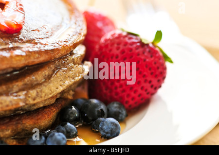 Pile de crêpes de sarrasin avec les baies fraîches et sirop d'érable Banque D'Images