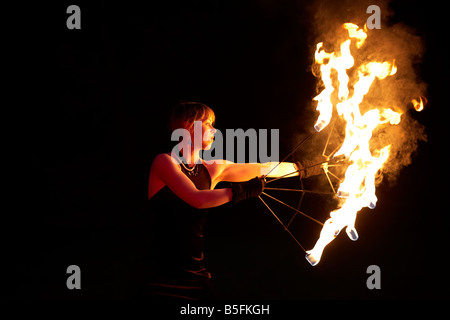 Femme firepoise fire dance performance holding fire fans la nuit effectuer Banque D'Images