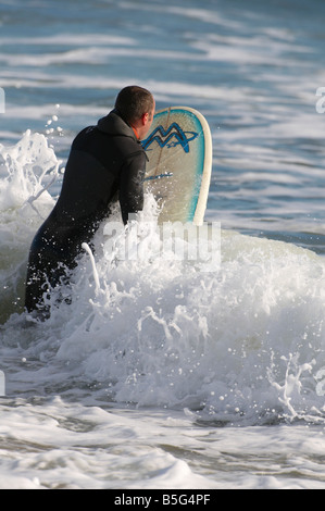 Homme surf sur la plage d''Aberdeen Scotland UK à l'automne Banque D'Images