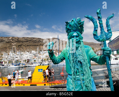 Artiste de rue Neptune habillé en attirant les touristes dans le sous-marin jaune de l'excursion en bateau à Puerto de Mogan Gran Canaria Espagne Banque D'Images