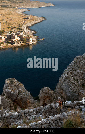 Un marcheur sur un chemin en pierre Kalderimi, raide, au-dessus du petit village de pêcheurs d'Yerolimenas dans le Grand Mani, Péloponnèse, Grèce Banque D'Images