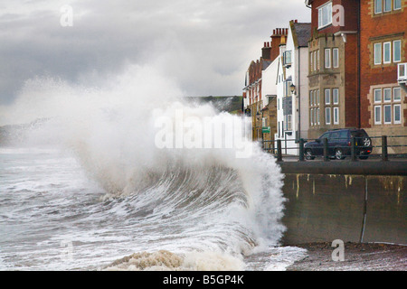 Dommages matériels et risques d'inondation au niveau du mur de la mer. Ondes géantes hautes avec onde de tempête, mur de réflexion d'onde de culasse à Sandside, Whitby, Yorkshire, Royaume-Uni Banque D'Images