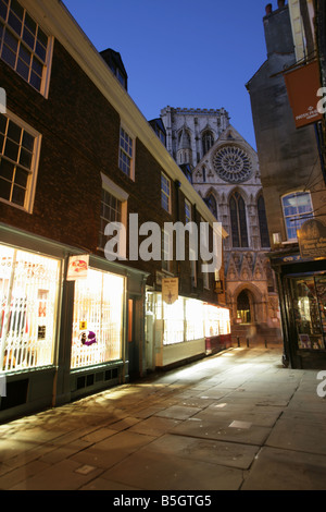 Ville de York, en Angleterre. Vue de la nuit de boutiques dans la Cathédrale avec la porte de l'entrée principale de la cathédrale de York dans l'arrière-plan. Banque D'Images