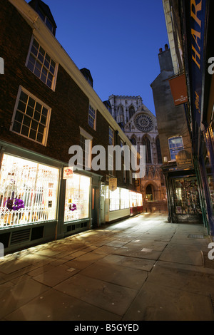 Ville de York, en Angleterre. Vue de la nuit de boutiques dans la Cathédrale avec la porte de l'entrée principale de la cathédrale de York dans l'arrière-plan. Banque D'Images