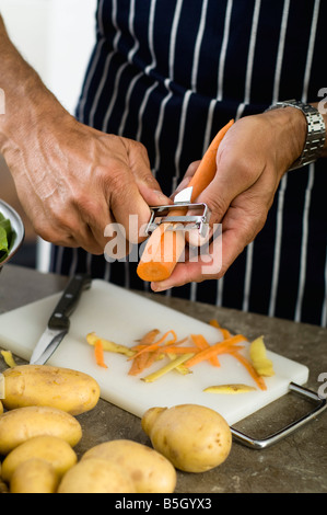 Man peeling carottes Banque D'Images