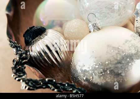 Ornements de Noël blanc et argent recueilli dans un bol en argent antique Banque D'Images