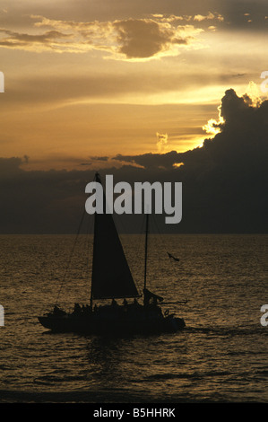 Voilier au coucher du soleil au large de la côte de Negril Jamaïque Banque D'Images