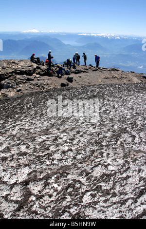 Les alpinistes amateurs prennent une pause sur le haut d'active Volcan Villarrica près de Pucón, Chili sur une journée ensoleillée. Banque D'Images