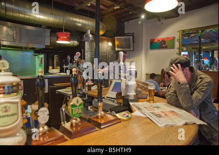 Un homme de la lecture d'un papier de nouvelles dans le château de Warwick, Pub, Portobello road London W11 Nottinghill Banque D'Images