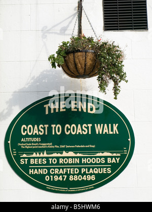 Inscrivez-vous sur le mur de l'hôtel Bay Robin Hoods Bay marquant la fin de la côte à l'autre à pied de St Bees dans Cumbria Banque D'Images