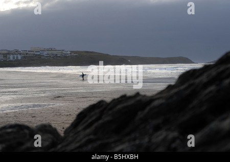 Un surfeur sur la plage de Newquay Banque D'Images