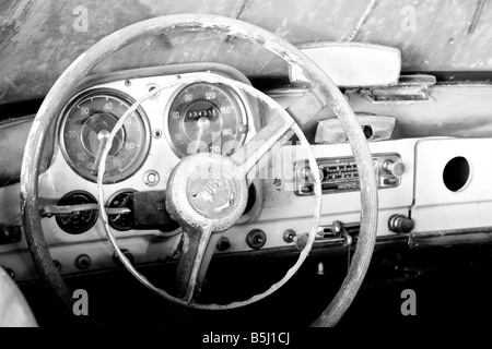 Haut contraste image en noir et blanc d'un volant et un tableau de bord d'une décapotable, une voiture classique perdus dans le temps. Banque D'Images