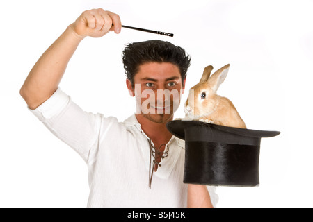 Jeune Magicien tenant une baguette magique au-dessus d'un lapin dans un chapeau haut de forme Banque D'Images