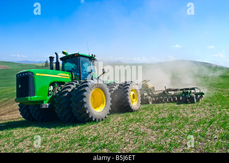 Un tracteur tire un semoir pneumatique à replanter le blé d'hiver endommagé par la neige au printemps dans la région de Washington Palouse Banque D'Images