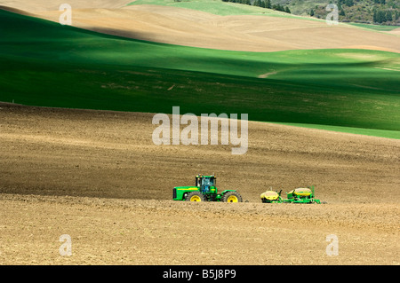 Un tracteur tire un semoir pneumatique à planter des céréales ou des légumineuses au printemps dans la région de Washington Palouse Banque D'Images