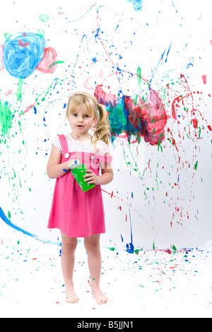 Jolie petite fille art student, peinture avec éclaboussures de peinture, graphique, des traînées et traces de daubs. Banque D'Images