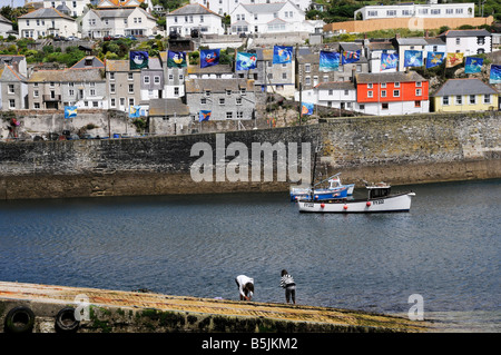 Deux jeunes filles pour les crabes de poissons sur le Harbourside à Mevagissey Cornwall sur une journée ensoleillée Banque D'Images