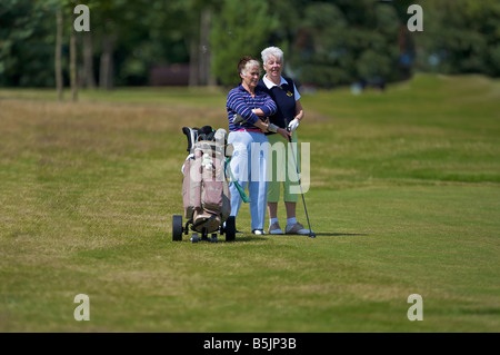 Deux golfeurs dame d'attendre pour jouer leurs tirs sur un cours de golf Banque D'Images