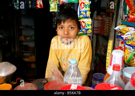 Jeune Indien boy holding street shop dans la région de Old Delhi Inde Banque D'Images