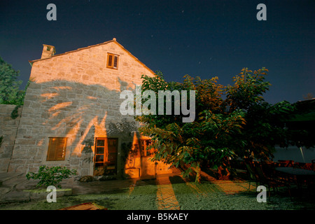 Photo de nuit de la maison avec l'ombre de palmiers casted mur Banque D'Images