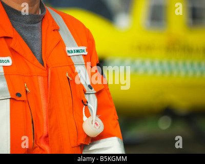 Battant les techniciens médicaux de l East Anglian Air Ambulance attendant à côté de l'hélicoptère d'urgence Banque D'Images