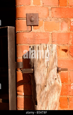 Détail d'une grange en brique rouge avec barrière en bois rustique dans le Herefordshire UK Banque D'Images