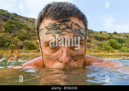 Portrait d'un homme couvert de boue patauger dans le lac Banque D'Images