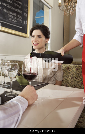 Serveuse de servir un verre de vin. Banque D'Images