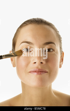 Une femme ayant appliqué avec un pinceau rouge Banque D'Images