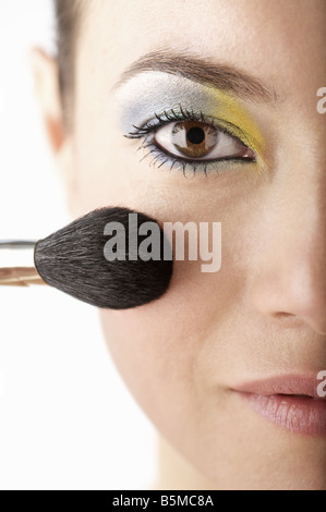 Une femme ayant appliqué avec un pinceau rouge Banque D'Images