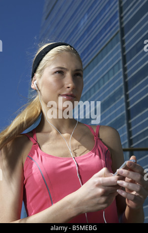 Une jeune femme de l'écoute d'un MP3 player Banque D'Images