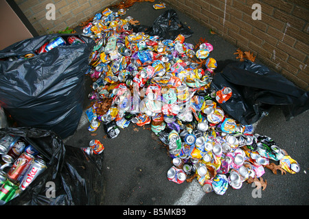 Pile de canettes de soda écrasé et sacs à déchets dans une ruelle Banque D'Images