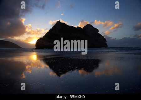 Îles d'Archway reflétée dans les sables humides de Wharariki Beach au coucher du soleil, près du cap Farewell NW Nelson Region ile sud Nouvelle Zelande Banque D'Images