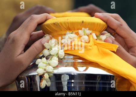 Closeup of hands dévot transportant le lait de coco pot pendant thaipusam festival, les grottes de Batu, Malaisie Banque D'Images