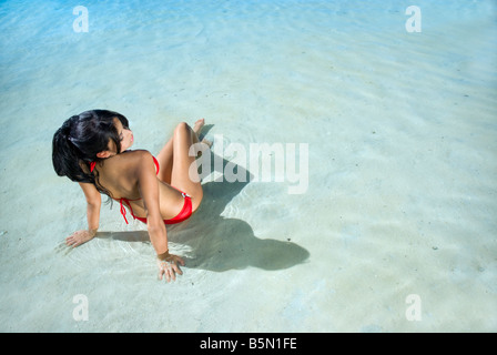Beautiful woman in red bikini se détend dans l'eau Banque D'Images