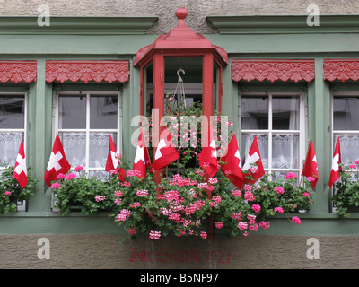 Fenêtres décorées de drapeaux et de fleurs petite suisse Banque D'Images