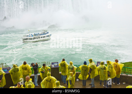 Bonnes de la brume voile touristes en jaune d'imperméables sous Horseshoe Falls sur la rivière Niagara, Ontario Canada Banque D'Images