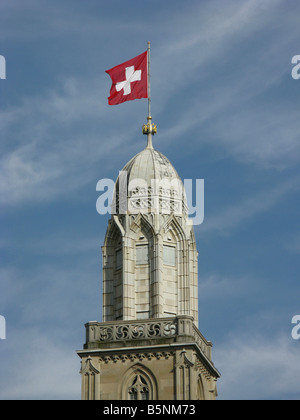 Drapeau national suisse sur le dessus de l'église Grossmünster de Zurich de la spire Banque D'Images