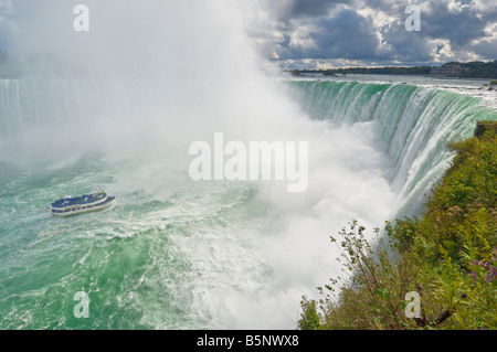 Bonnes de la brume voile croisière avec les touristes en bleu d'imperméables Horseshoe Falls sur la rivière Niagara, Ontario Canada Banque D'Images