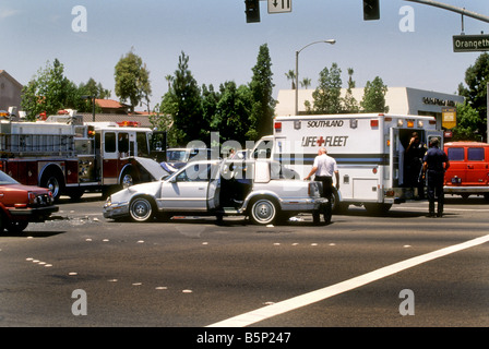 Les policiers et les ambulanciers traitent de auto collision. Banque D'Images