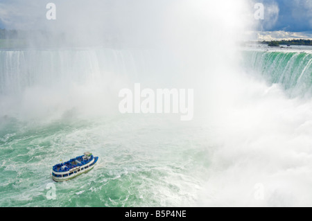 Bonnes de la brume voile croisière avec les touristes en bleu d'imperméables Horseshoe Falls sur la rivière Niagara, Ontario Canada Banque D'Images