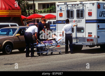 Les agents de police et les traiter en parmedics auto collision. Banque D'Images