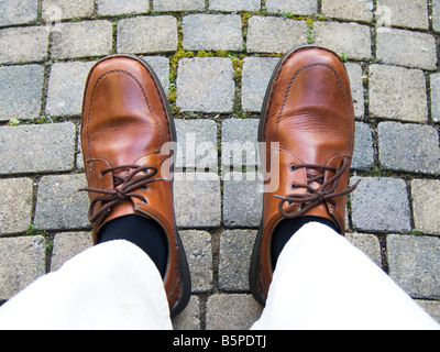 Un homme dans les pieds chaussures brunes