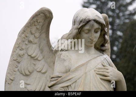 Statue sculpture ange pierre tombale cimetière hiver Banque D'Images