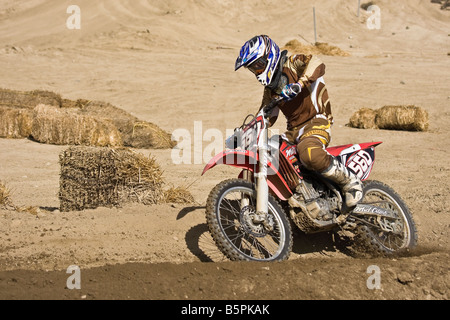 Cross rider déferle sur un coude à Glen Helen Devore circuit en Californie. Banque D'Images