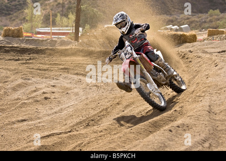 Cross rider déferle sur un coude à Glen Helen Devore circuit en Californie. Banque D'Images