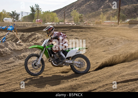 Cross rider déferle sur un coude à Glen Helen Devore circuit en Californie. Banque D'Images